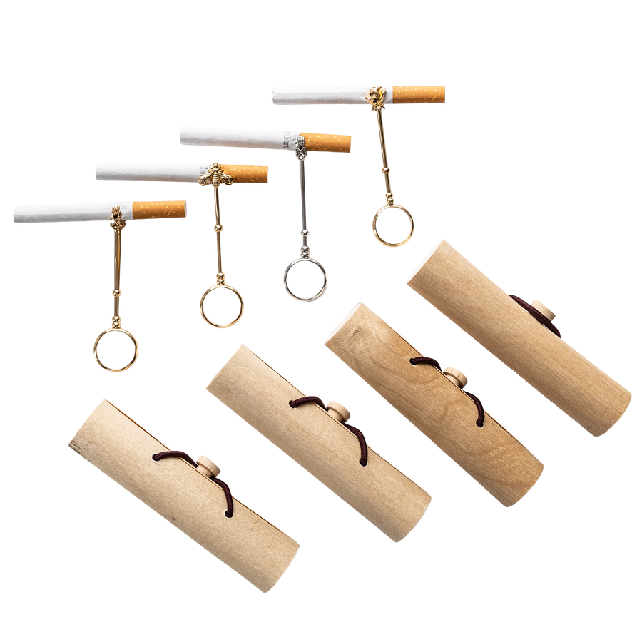 Gold-tone and silver-tone cigarette holder rings displayed with cigarettes and cylindrical cases