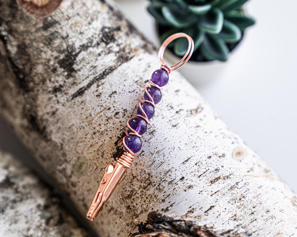 Purple beaded wand cigarette holder on a birch display