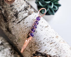 Purple beaded wand cigarette holder on a birch display