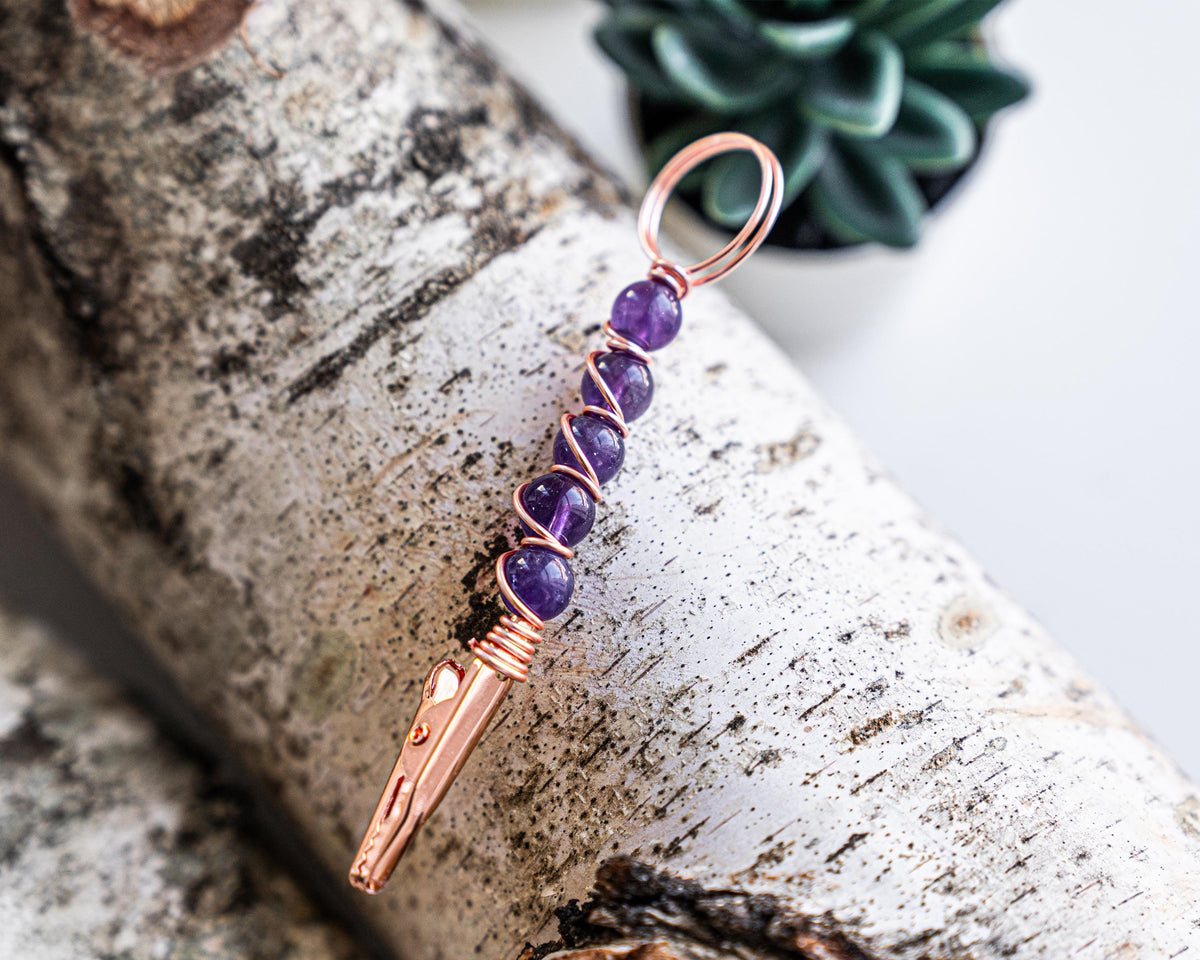 Purple beaded wand cigarette holder on a birch display