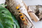 Honey bee wand cigarette holder on a leafy display