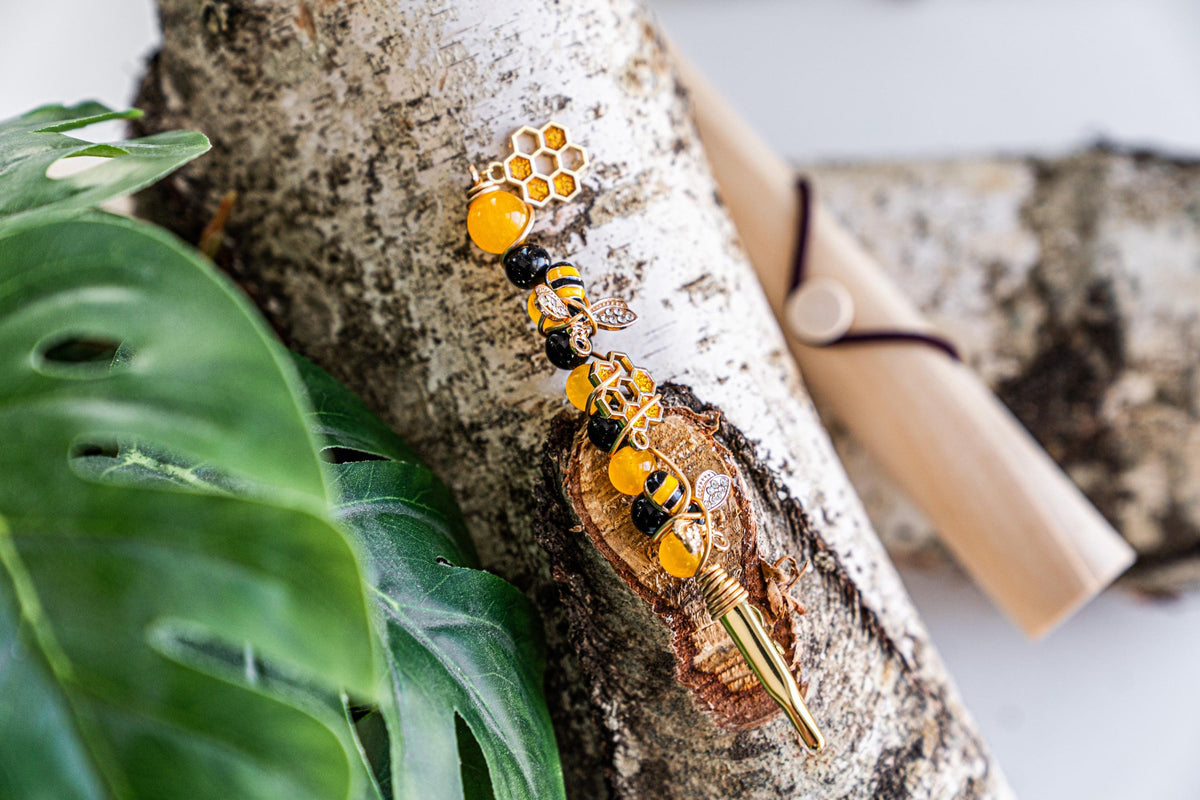 Honey bee wand cigarette holder on a leafy display