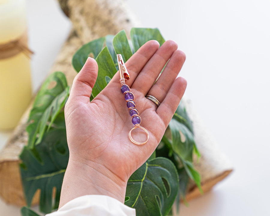 Gold-tone purple beaded wand cigarette holder shown in hand