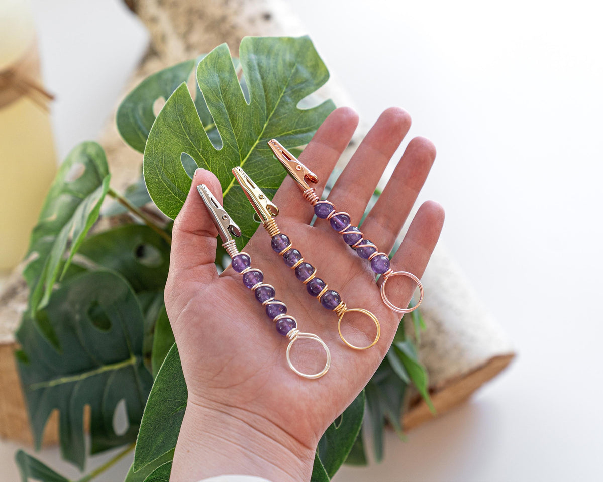 Silver-tone purple beaded wand cigarette holder shown in hand