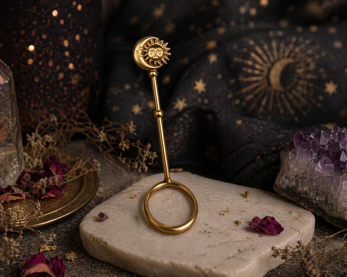 Gold-tone sun and moon cigarette holder ring on a dark display