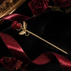 Gold rose cigarette holder on red and black fabric