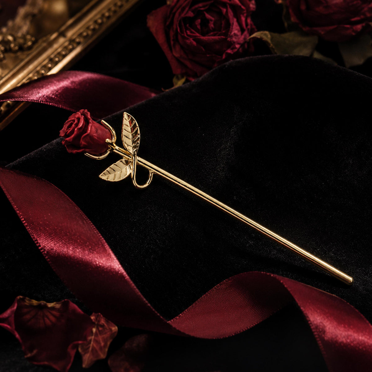 Gold rose cigarette holder on red and black fabric